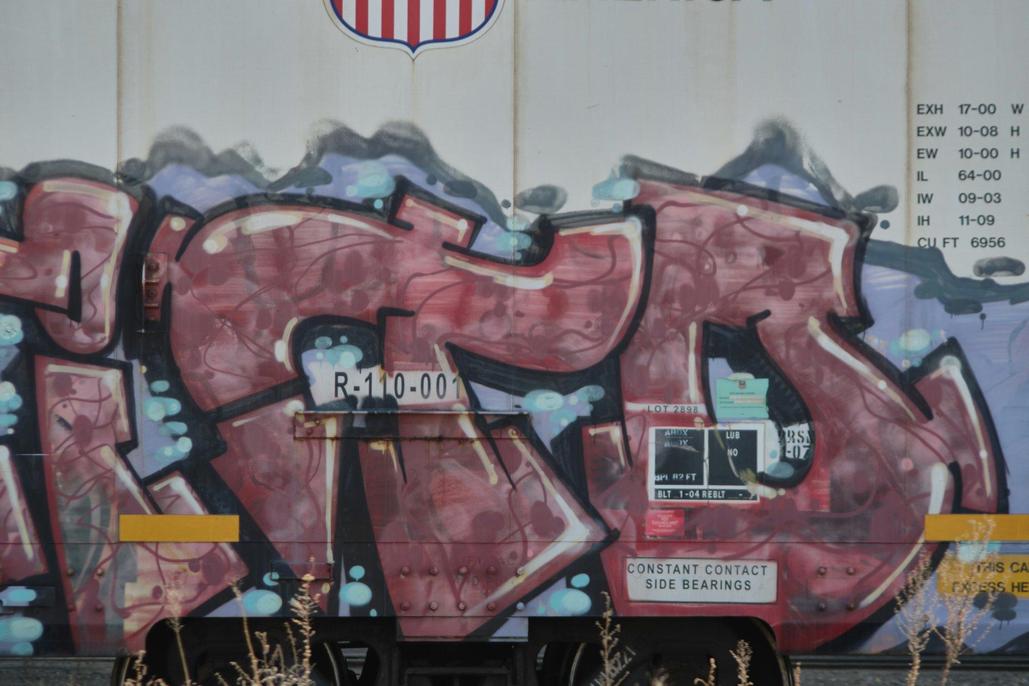 Two smiling individuals standing next to a chart displaying cost savings due to asbestos health policies